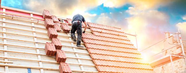 Mitarbeiter deckt das Dach seines Hauses und geht einer unerlaubten Nebentätigkeit nach