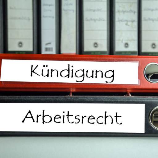Ein roter Akrenordner mit der Aufschrift Kündigung. Ein schwarzer Aktenordner mit der Aufschrift Arbeitsrecht
